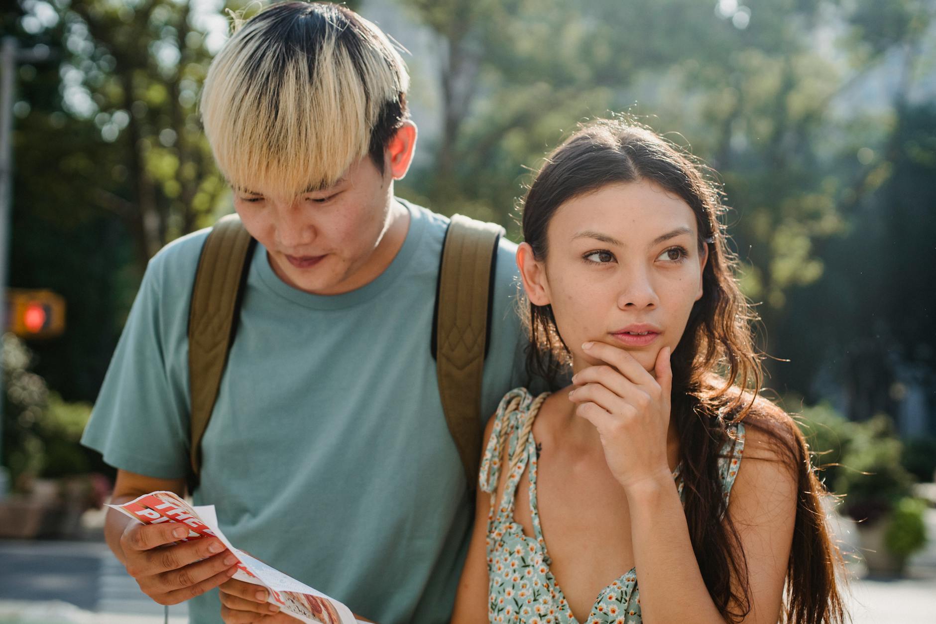 Confused couple consulting a map while exploring a city as tourists