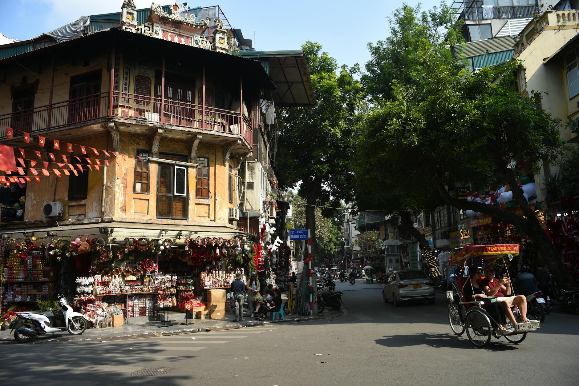 Lively Hanoi Old Quarter street with traditional architecture and rickshaw