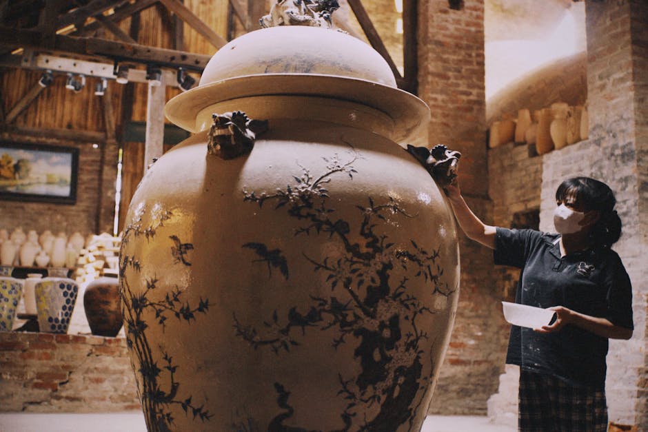 Skilled artisan works on large ceramic vase