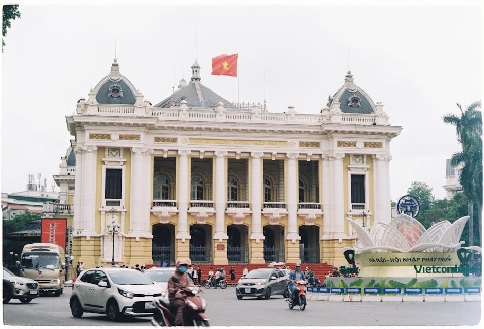 Hanoi Opera House with Vietnamese flag and traffic