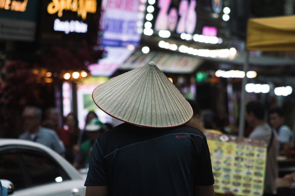 Man in conical hat at Hanoi night market