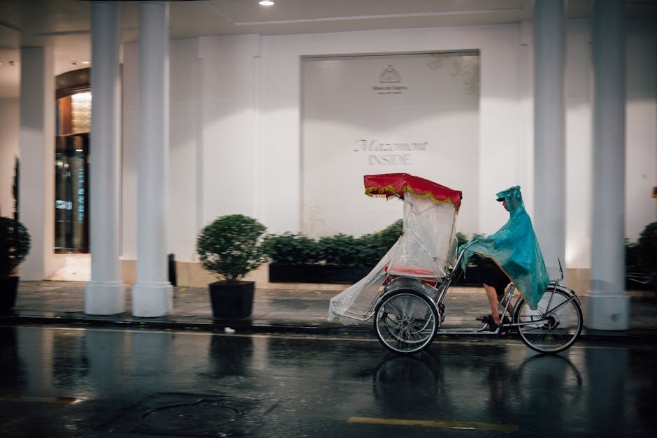 Cyclist in raincoat in tropical rain Hanoi