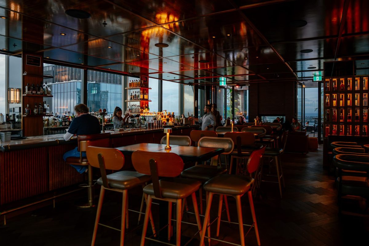 Cocktails at a Hanoi rooftop bar overlooking the city skyline at night