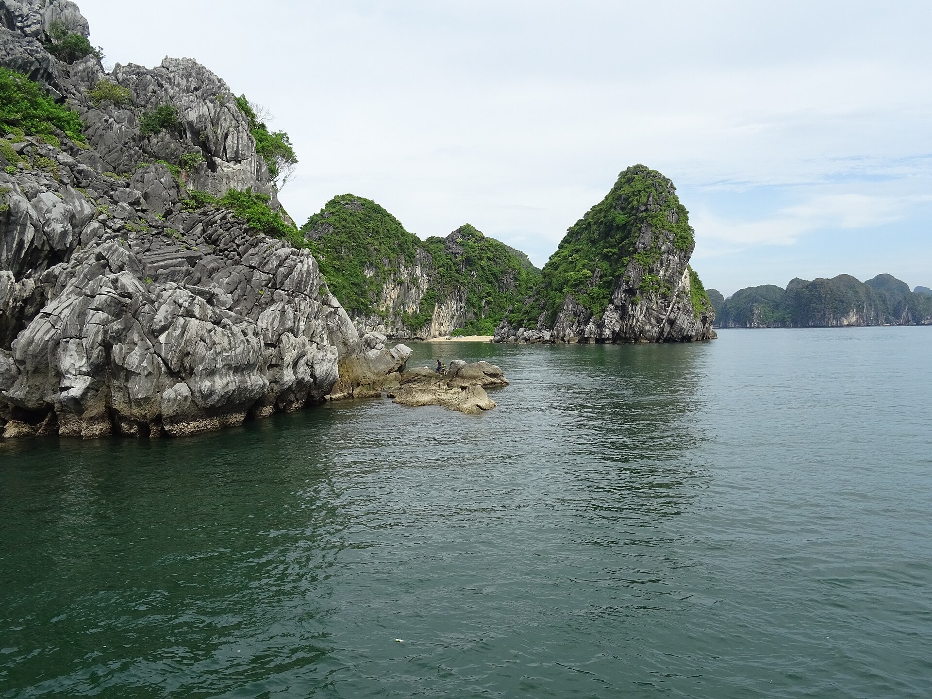 Lan Ha Bay vs Ha Long Bay: Which to Book 1 A small crescent of sand tucked between steep limestone islands in Lan Ha Bay